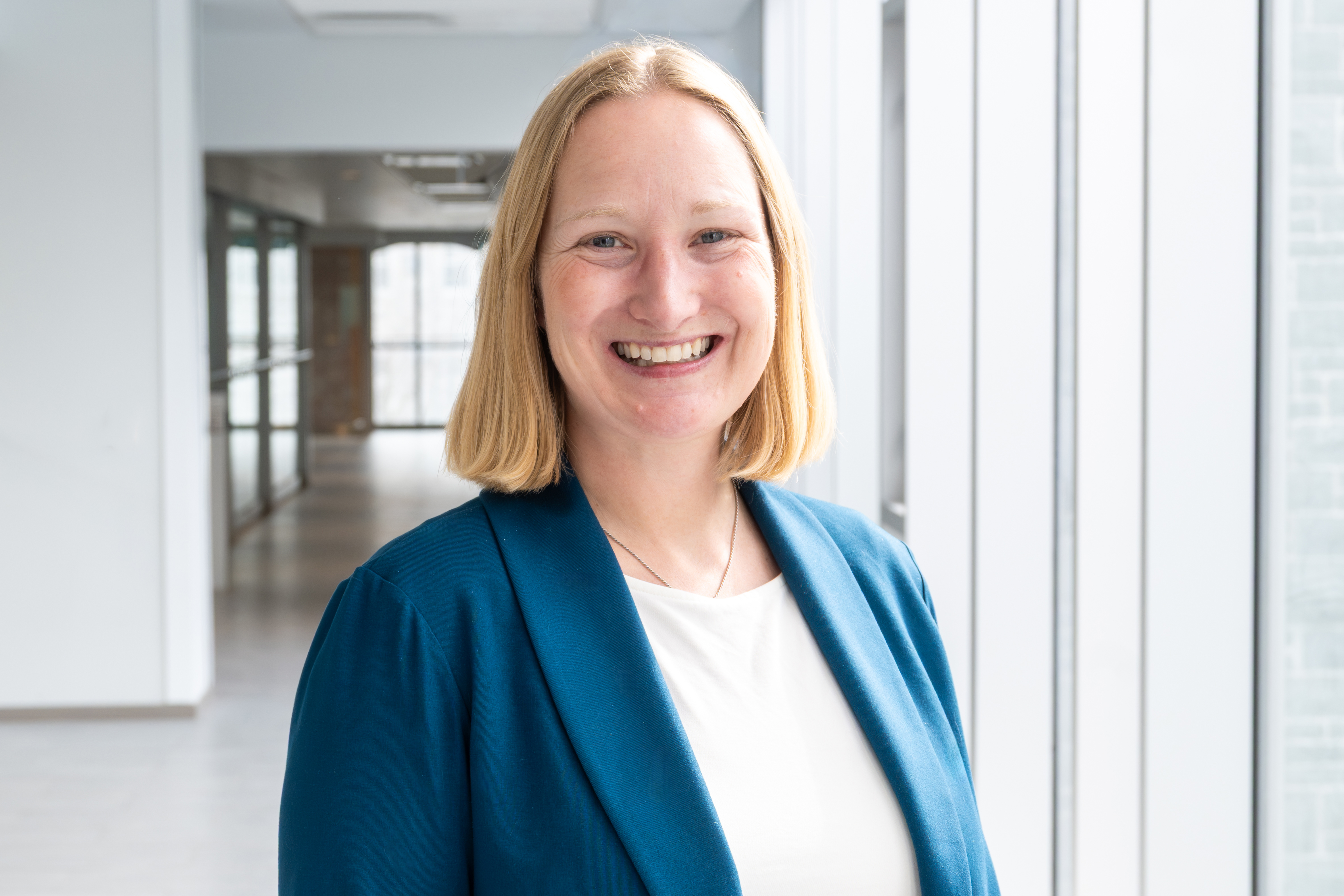 White woman with strawberry blond hair smiling at the camera