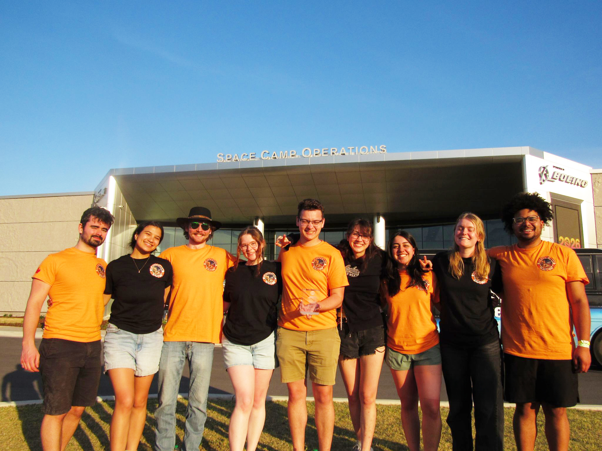 group of students standing in front of a building