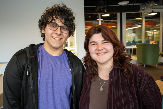 two young students smiling into the camera 