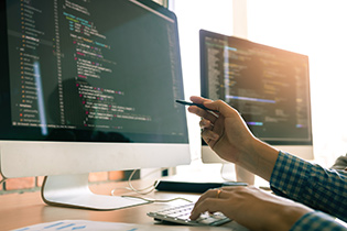 side view of a monitor with a hand holding a pen pointing it