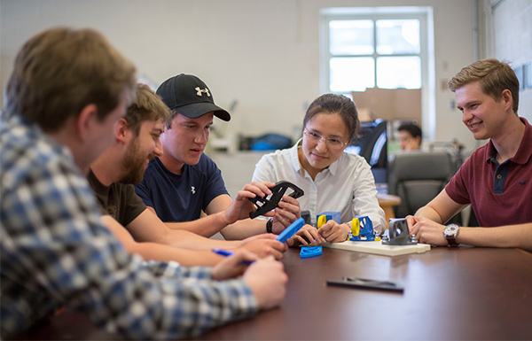 Researchers examine a 3D printed prototype as part of validating a Design for Additive Manufacturing (DfAM).